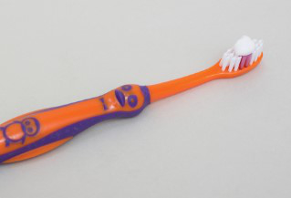 3-6 years penguin toothbrush with a pea size blob of toothpaste on white background.