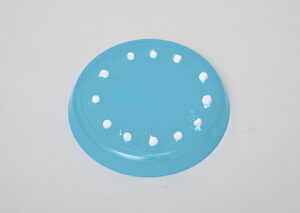 pea-sized amounts of toothpaste dispensed onto a plastic plate with spaces to allow children to safely apply toothpaste to their toothbrush